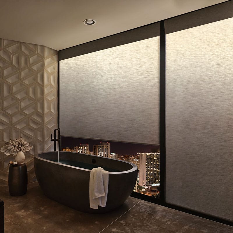 Modern city view bathroom with black freestanding tub, decorative wall, ambient lighting, elegant decor, spacious layout, nighttime cityscape, sophisticated design.