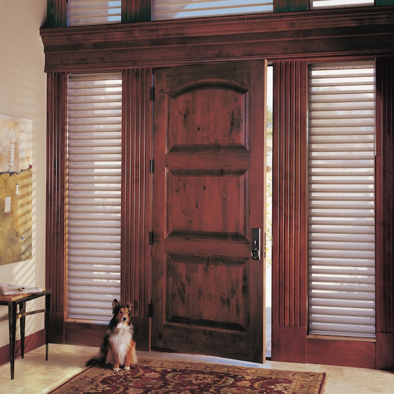 Elegant wooden front door with shutters in a cozy home interior.