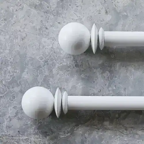 Stylish white curtain rods with spherical finials, ideal for modern window treatments, showcasing sleek design and smooth finish for home decor.