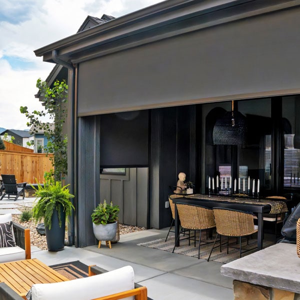 Contemporary outdoor patio featuring a retractable awning, dining area, and lush greenery for outdoor living and entertainment.