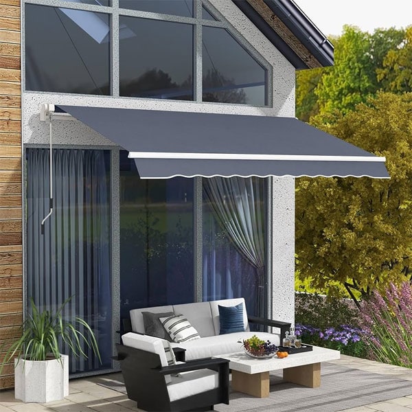 Stylish gray retractable awning providing shade over outdoor seating area with sofa and coffee table.